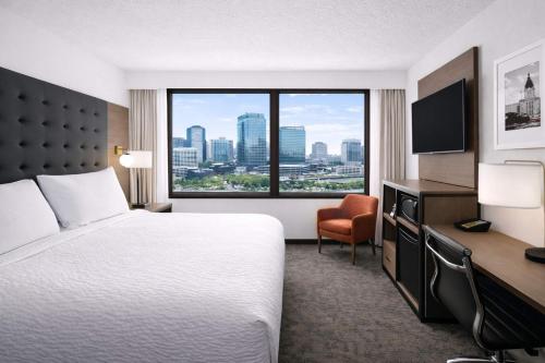 a hotel room with a bed and a large window at Ramada Plaza by Wyndham Regina Downtown in Regina
