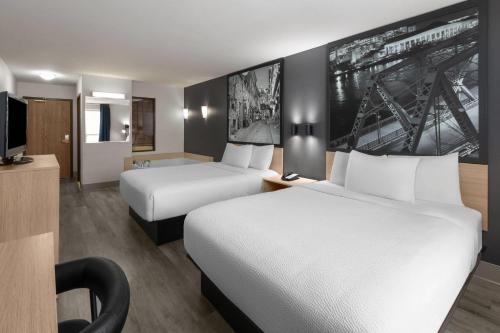 a hotel room with two beds and a tv at Super 8 by Wyndham Quebec City in Quebec City