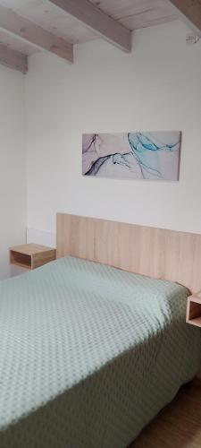 a bed in a room with a painting on the wall at Balcon al dique in Las Chacras
