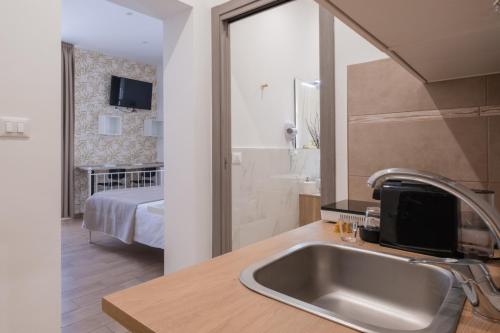 a bathroom with a sink and a bedroom with a bed at Rooms 2Binari in Bologna