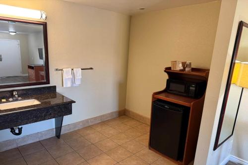a bathroom with a sink and a microwave at Travelodge by Wyndham Hemet CA in Hemet