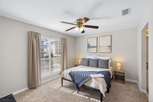 a bedroom with a bed and a ceiling fan at Spacious 2BR House, Steps from A&M - King - Patio in College Station