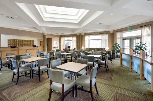 a dining room with tables and chairs and windows at La Quinta by Wyndham Haywood Mall-Near Greenville Downtown in Greenville