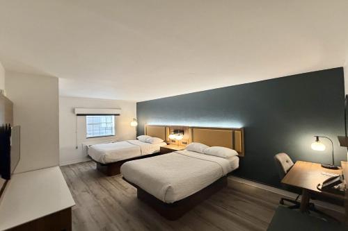 a hotel room with two beds and a desk at La Quinta Inn by Wyndham Salt Lake City Midvale in Midvale