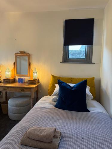 ein Schlafzimmer mit einem Bett, einem Spiegel und einem Schreibtisch in der Unterkunft CloudZen in Kent