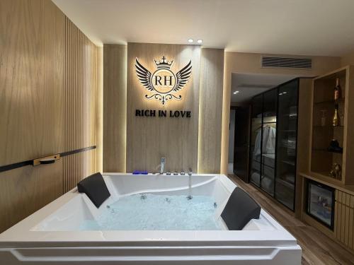 a large bath tub in a bathroom with a sign at Rich Hotel in Pogradec