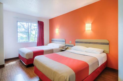 two beds in a room with orange walls at Motel 6-Lakeville, MN - South - Lakeville in Lakeville
