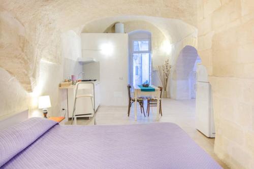 1 dormitorio con 1 cama, mesa y sillas en Dimora nei Sassi, en Matera