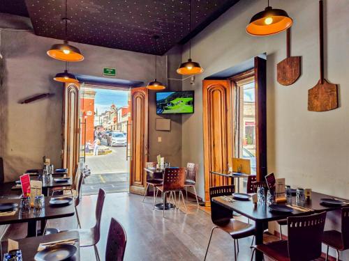 a restaurant with tables and chairs and a view of a street at Pórtico Hotel & Galería in Morelia