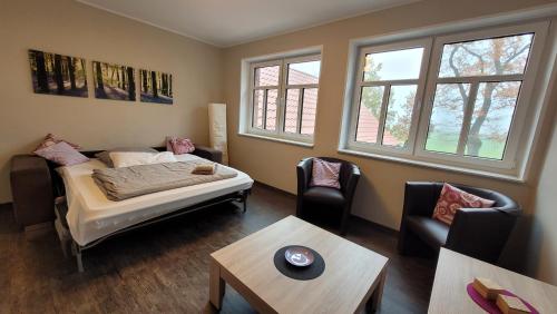 a room with a bed and two chairs and a table at Hof Hahnenberg in Wagenfeld