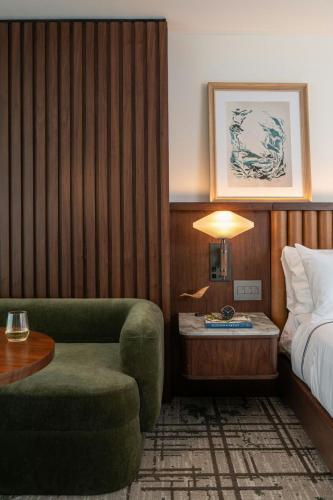 a hotel room with a bed and a chair and a table at The Greenleigh, River Oaks, Autograph Collection in Houston