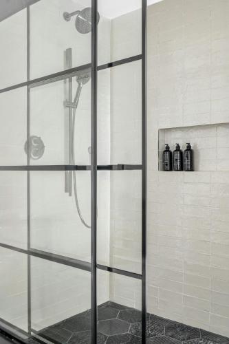 a shower with a glass door in a bathroom at The Greenleigh, Autograph Collection in Houston