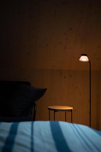 a lamp in a room with a bed and a table at Domek Orlické hory in Deštné v Orlických horách
