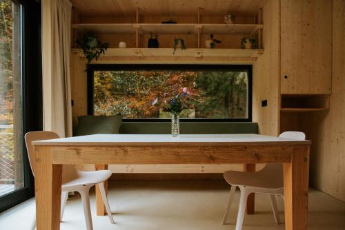 a dining room table with two chairs and a window at Domek Orlické hory in Deštné v Orlických horách