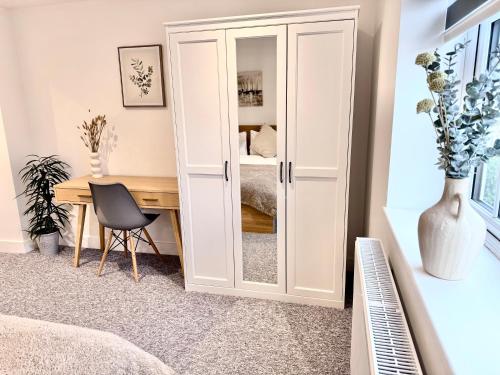 a bedroom with a desk and a cupboard at Spacious En-suite Private Double Bedroom in Oxford