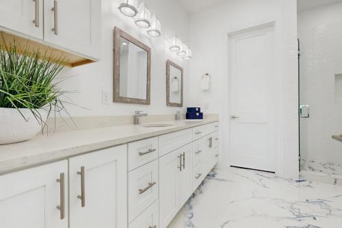 a white bathroom with a sink and a mirror at Tortuga Palms in Rockport