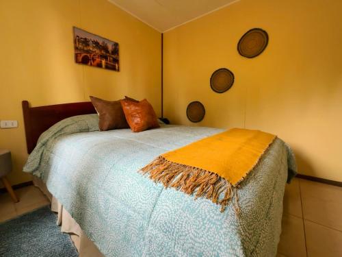 a bedroom with a bed with a blanket on it at Cabaña rincón del salto in Cabrero