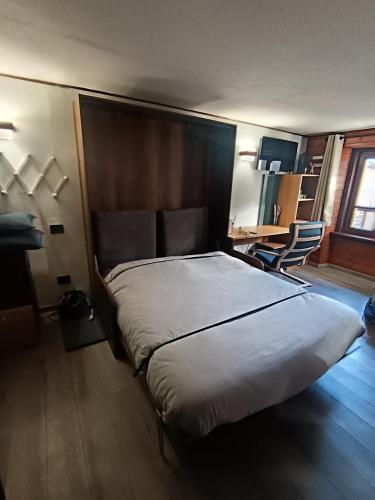 a bedroom with a large bed and a desk at Bilocale Centro Valtournenche in Valtournenche
