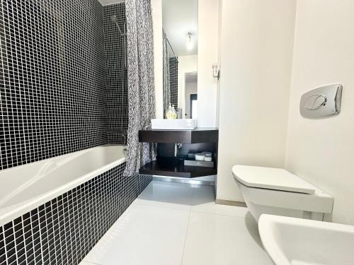 a bathroom with a toilet and a sink and a tub at Precious Relaxation Rooms in Funchal in Funchal