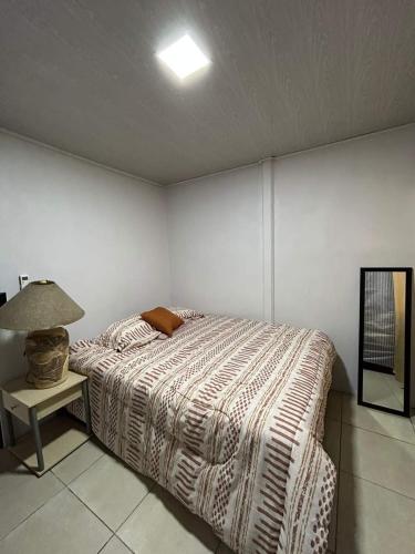 a bedroom with a bed and a lamp on a table at Casa Roma in Chorro