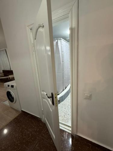 a bathroom with a door with a shower and a toilet at Emilia Hotel Batumi Old Town in Batumi