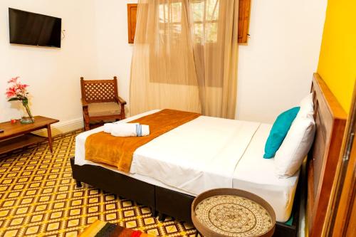 a hotel room with a bed and a chair at Hotel Casa Real Villeta in Villeta
