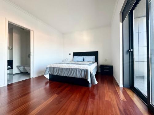a bedroom with a bed and a wooden floor at Precious Relaxation Rooms in Funchal in Funchal