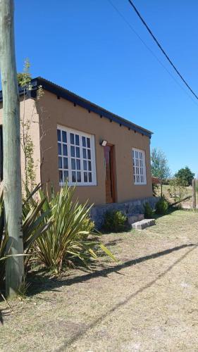 a small house with a tree in front of it at Cabaña la Monita in Tandil