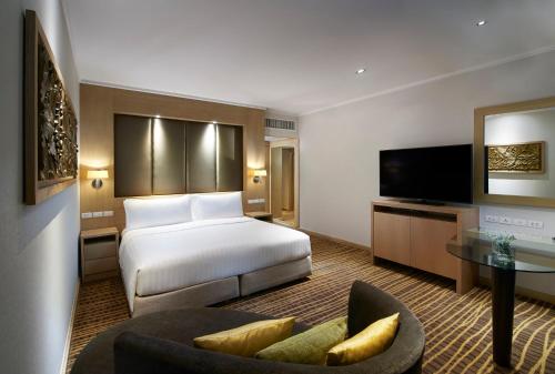a hotel room with a bed and a tv at Amari Bangkok in Bangkok