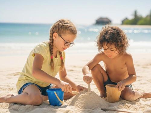 two children playing in the sand on the beach at Bougain Villa Gemanafushi in Gemanafushi