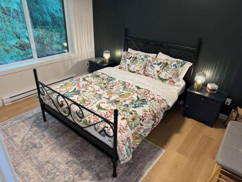 a bedroom with a bed with a floral comforter and two night stands at Island Coastal Retreat in Nanaimo