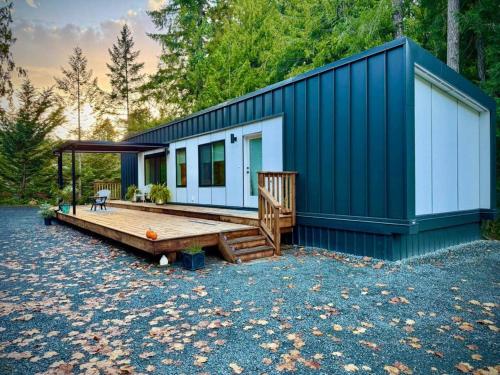 a blue and white house with a wooden deck at Island Coastal Retreat in Nanaimo
