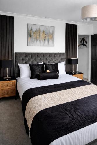 a bedroom with a large black and white bed at Rosie House 3 bedroom House in Sandbach with Parking in Sandbach