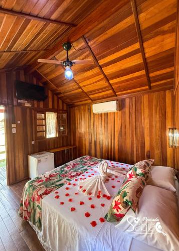 a large bed in a room with wooden walls at Pousada Sabiá in Brotas