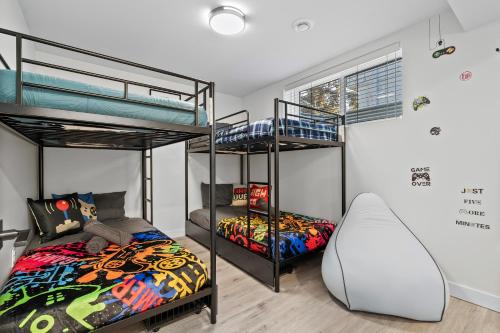 two bunk beds and a bed in a room at Cosmic Game Room, Yard & Close to WEM in Spruce Grove