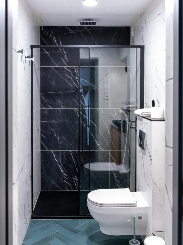 a bathroom with a toilet and a glass shower at Arte-locum Apartamenty przy Rynku in Wrocław
