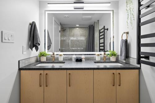 a bathroom with two sinks and a large mirror at Cosmic Game Room, Yard & Close to WEM in Spruce Grove
