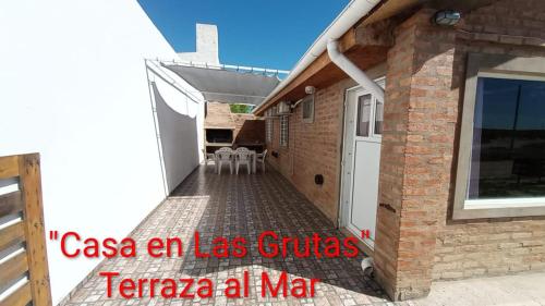 a house with a white door and a brick wall at Casa en Las Grutas in Las Grutas