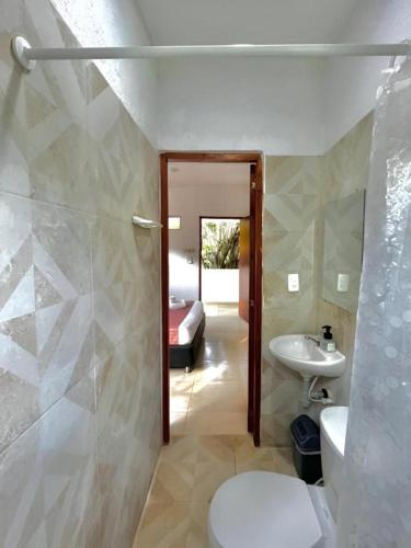 a bathroom with a toilet and a sink and a tub at Manigua Tayrona Hostel in Santa Marta