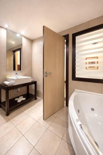 a bathroom with a tub and a sink at INOH Athens Hotel in Athens