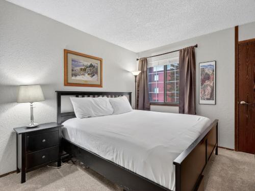 a bedroom with a large bed and a window at Giant Steps 28 Ski in out in Brian Head