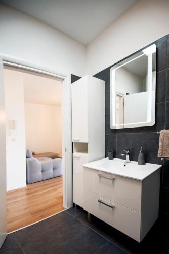 a bathroom with a white sink and a mirror at Apartman Denis in Pula