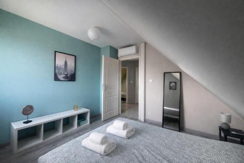 a bedroom with two white towels on a bed at Sérénité Alsacienne, jardin, terrasse et clim, Nord Alsace in Seltz
