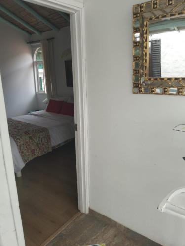 ein Schlafzimmer mit einem Bett und einem Spiegel an der Wand in der Unterkunft Hostal La Cestería Pueblito Boyacense in Duitama