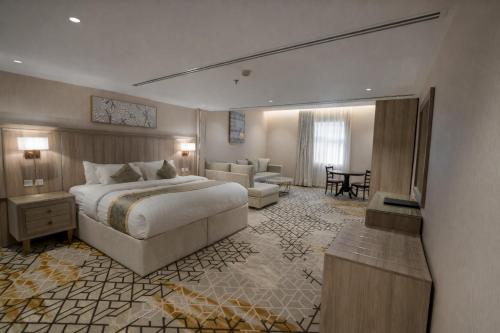 a hotel room with a bed and a living room at Grand Line in Tabuk