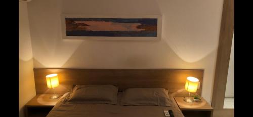 a bedroom with a bed with two lamps on it at Diamond Flat Aparthotel REDE Mont Blanc in Nova Iguaçu