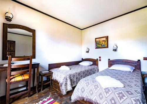 a bedroom with two beds and a mirror at Къща за гости Старият Град Златоград in Zlatograd