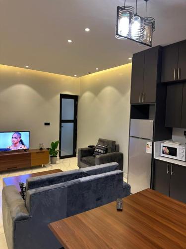 a living room with a couch and a tv at Bright 1BR Apartment Close to Everything in Kigali