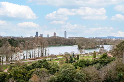 a view of a lake with a city in the background at Lyon Marriott Hotel Cité Internationale in Lyon