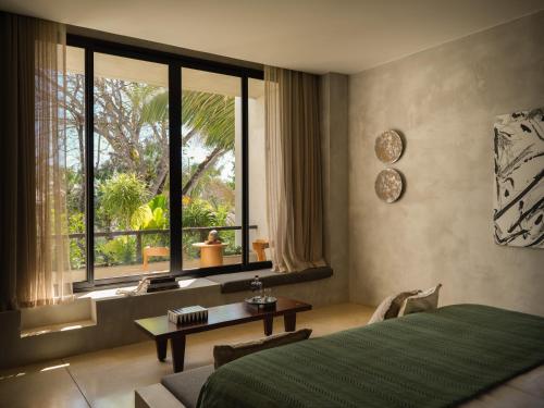 a bedroom with a bed and a large window at Esh Hotel & Spa, a Member of Design Hotels in Nosara